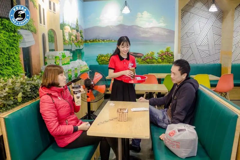 Hình ảnh nhân viên đang bê trà sữa cho khách