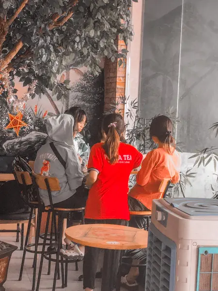 Hình ảnh nhân viên quán trà sữa pozaa Tea đang phục vụ khách hàng.