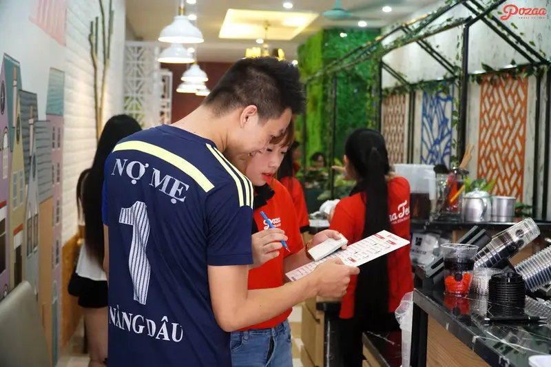 Hình ảnh nhân viên quán trà sữa Pozaa Tea đang order cho khách.