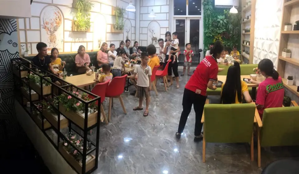 Hình ảnh nhân viên quán trà sữa Pozaa Tea đang phục vụ khách hàng.