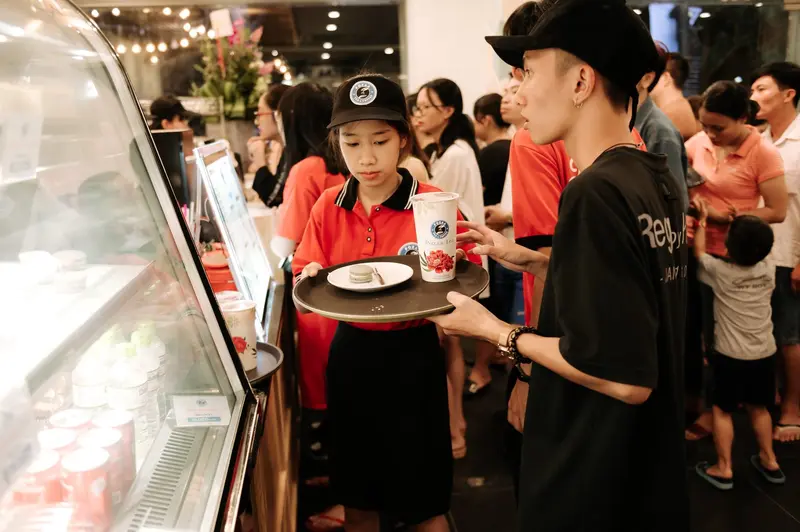 Hình ảnh nhân viên quán trà sữa Pozaa Tea phục vụ khách hàng.