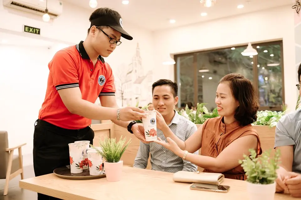 Hình ảnh nhân viên quán trà sữa Pozaa Tea phục vụ khách hàng.