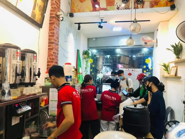 Hình ảnh nhân viên quán trà sữa Pozaa Tea đang tiếp đón khách hàng.