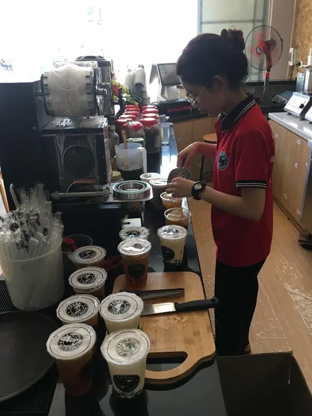 Hình ảnh nhân viên quán trà sữa Pozaa Tea đang pha chế.